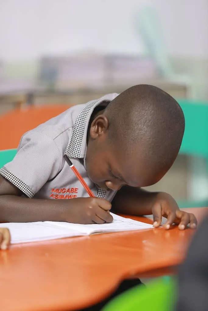 A boy concentrating as he writes in his book
